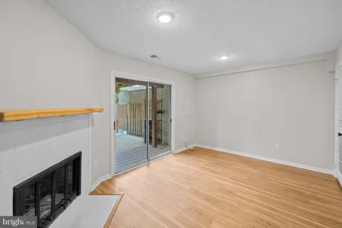 a view of empty room with wooden floor and fireplace