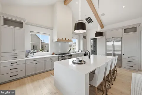 a kitchen with a dining table chairs sink and stove