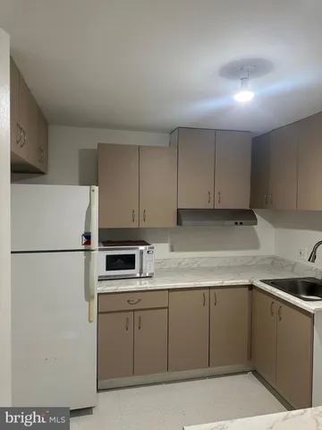 a kitchen with cabinets appliances a sink and a counter top