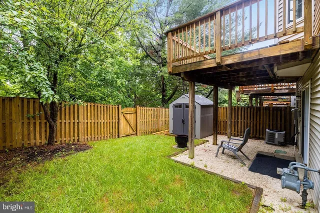 a view of a backyard with a tub and wooden fence