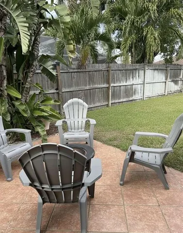 a living room with patio furniture and a floor to ceiling window