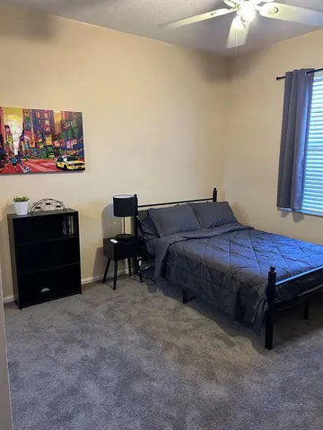 a bed sitting in a bedroom next to a window