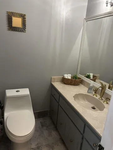 a bathroom with a granite countertop sink and a mirror
