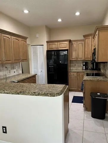 a kitchen with stainless steel appliances granite countertop a refrigerator and a sink