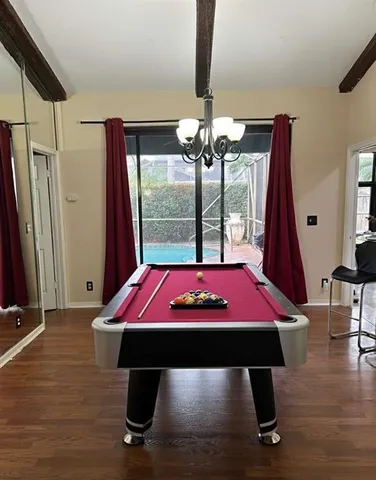 a view of a room with wooden floor table and windows