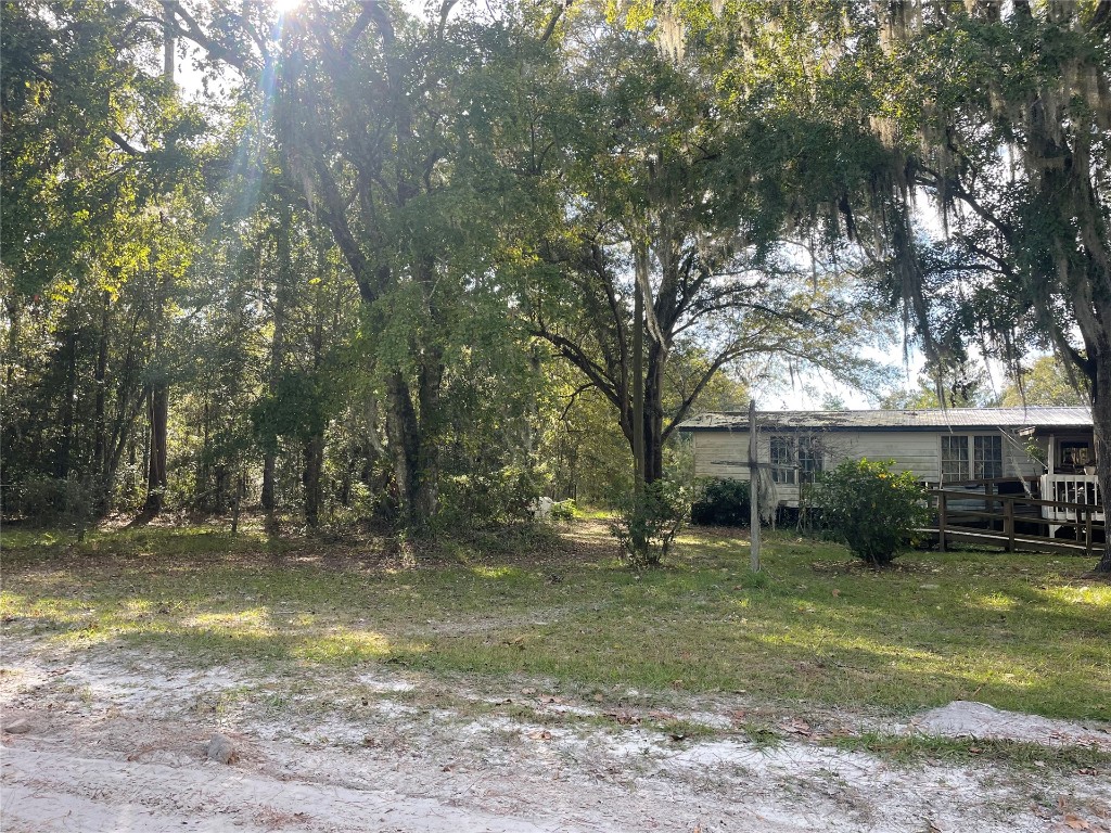 15206 Howard Road Bryceville, FL 32009 - Photo 5 of 13 a backyard of a house with garden and outdoor seating