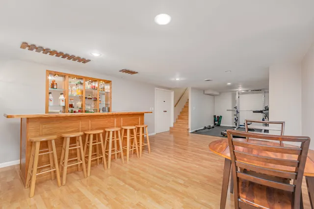 a dining hall with stainless steel appliances kitchen island granite countertop a dining table chairs and a white refrigerator