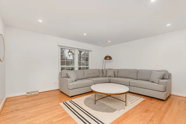 a living room with furniture a rug and a table