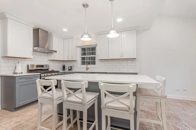 a kitchen with a table chairs microwave and cabinets