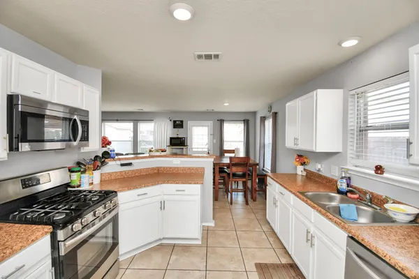 a large kitchen with stainless steel appliances granite countertop a stove and a sink