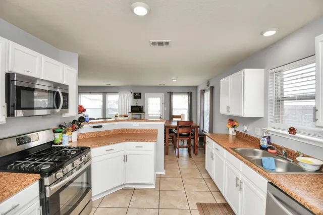 a large kitchen with stainless steel appliances granite countertop a stove and a sink
