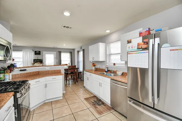 a kitchen with white cabinets and appliances