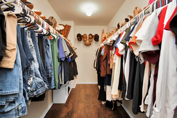 a view of walk in closet with clothes and shoes