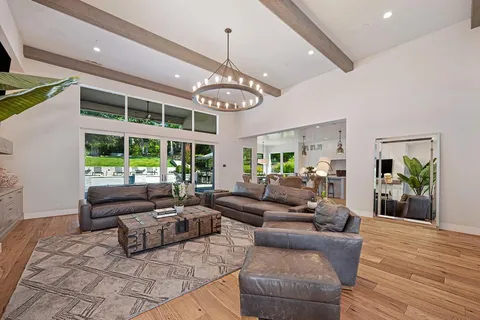 a large kitchen with kitchen island a large island in the center a sink stainless steel appliances and cabinets