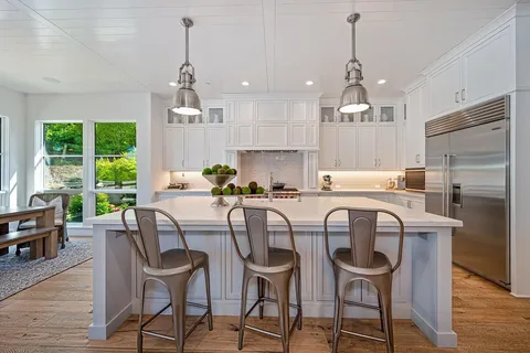a kitchen with granite countertop white cabinets and stainless steel appliances