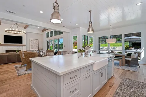 a kitchen with stainless steel appliances granite countertop a sink a stove and cabinets