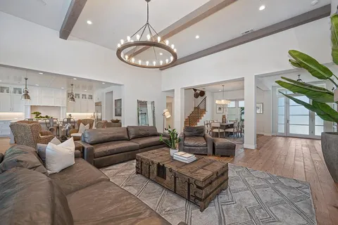 a dining room with wooden floor a chandelier a wooden table and chairs