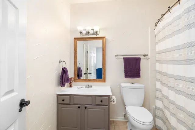 a bathroom with a toilet a sink and mirror