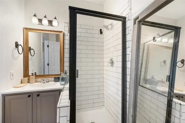 a bathroom with a shower sink and mirror