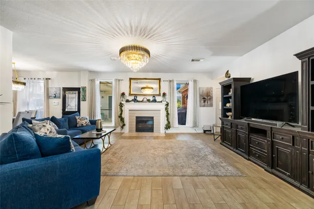 a living room with furniture a flat screen tv and a fireplace