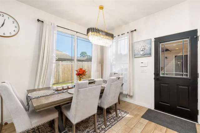 a dining room with furniture a chandelier and wooden floor
