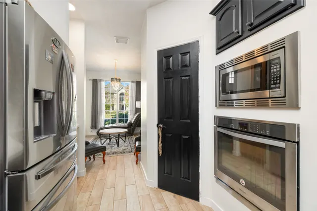 a kitchen with granite countertop stainless steel appliances and wooden floor