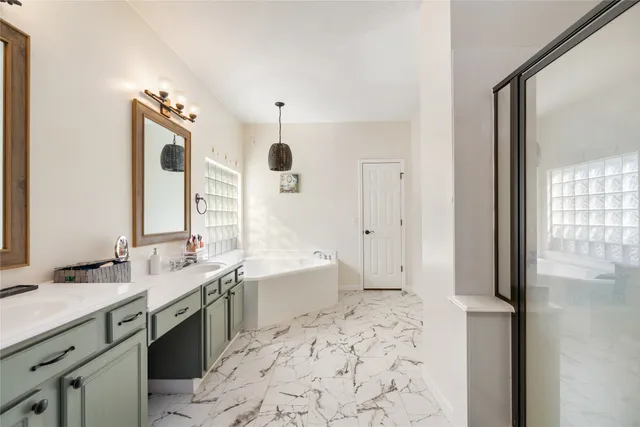 a spacious bathroom with a bathtub sink and mirror