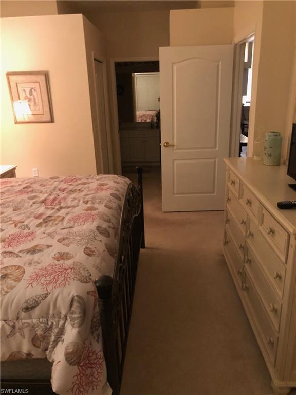 1911 Morning Sun Lane Naples, FL 34119 - Photo 12 of 17 a bedroom with a bed and a mirror