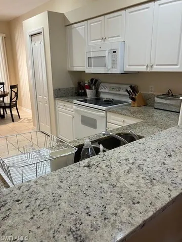a kitchen with granite countertop a sink and a stove top oven