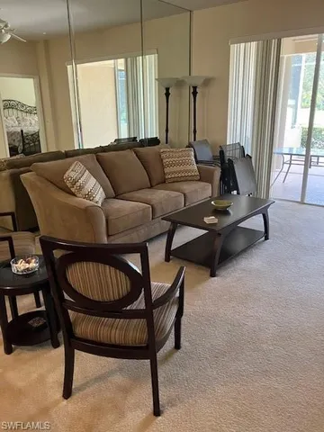 a living room with furniture a rug and a chandelier