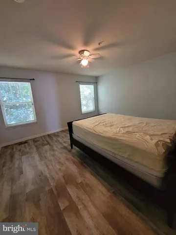 a bed sitting in a bedroom and night stand