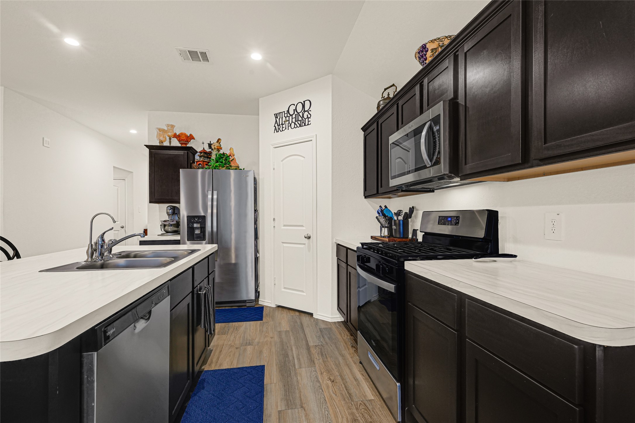 14968 Bergamot Colony Street Splendora, TX 77372 - Photo 12 of 25 a kitchen with a sink dishwasher a stove and a refrigerator with wooden floor