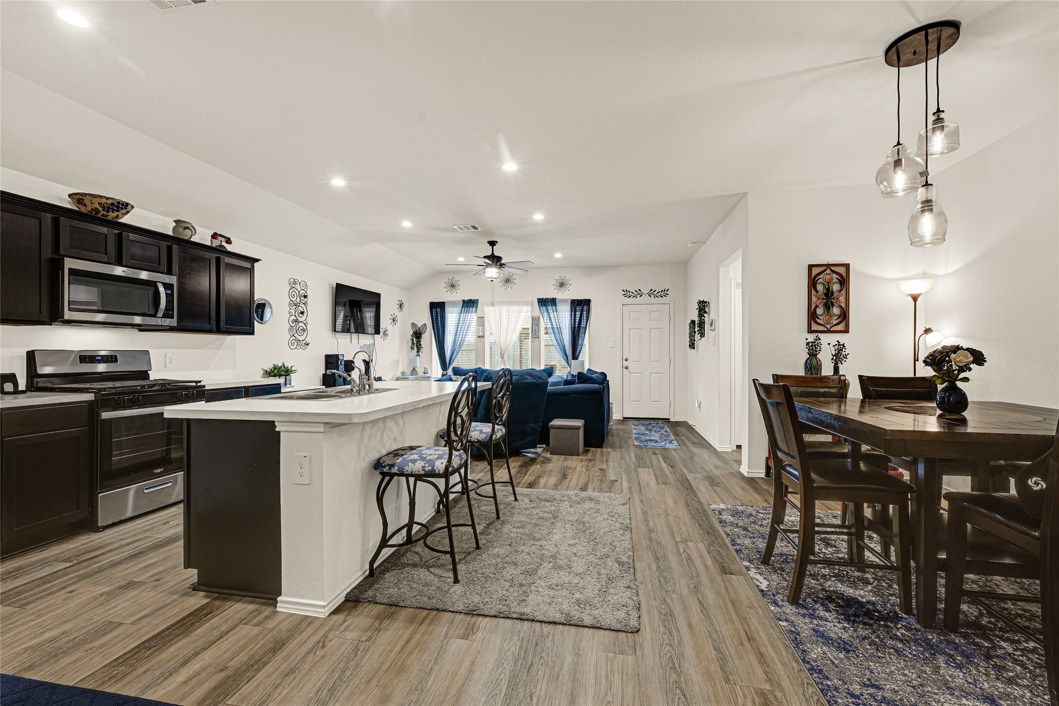 14968 Bergamot Colony Street Splendora, TX 77372 - Photo 15 of 25 a living room with stainless steel appliances kitchen island granite countertop furniture wooden floor and a view of kitchen