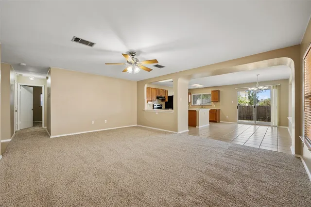 a view of a big room with wooden floor and a kitchen
