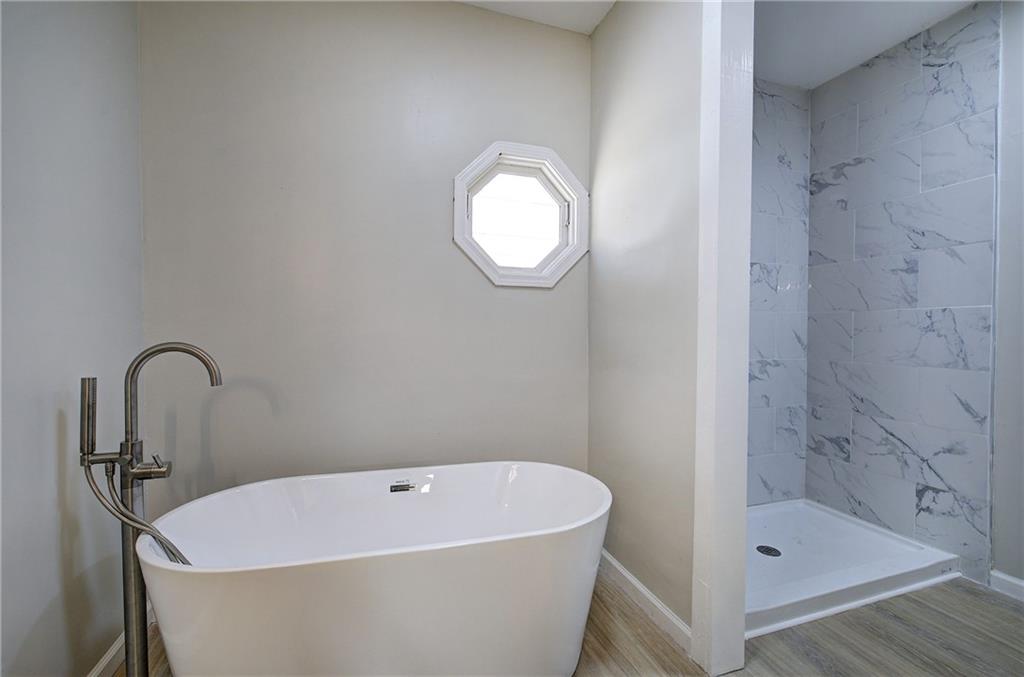 2193 West Ellis Road Griffin, GA 30223 - Photo 11 of 26 a white bath tub sitting next to a shower