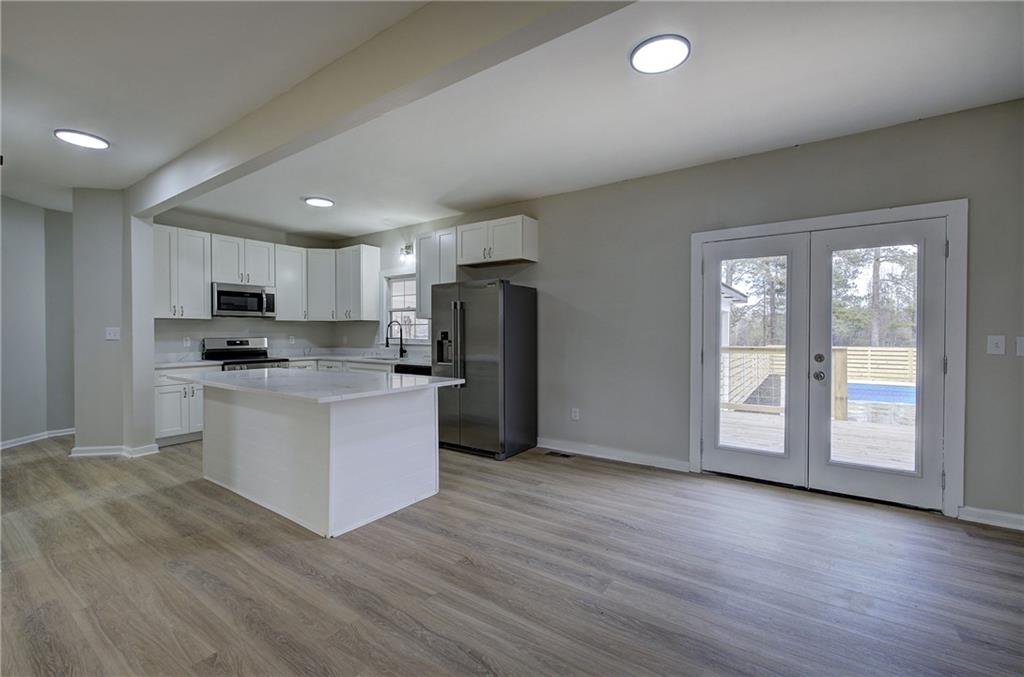 2193 West Ellis Road Griffin, GA 30223 - Photo 2 of 26 a kitchen with stainless steel appliances granite countertop a refrigerator a sink dishwasher a stove and white countertops with wooden floor