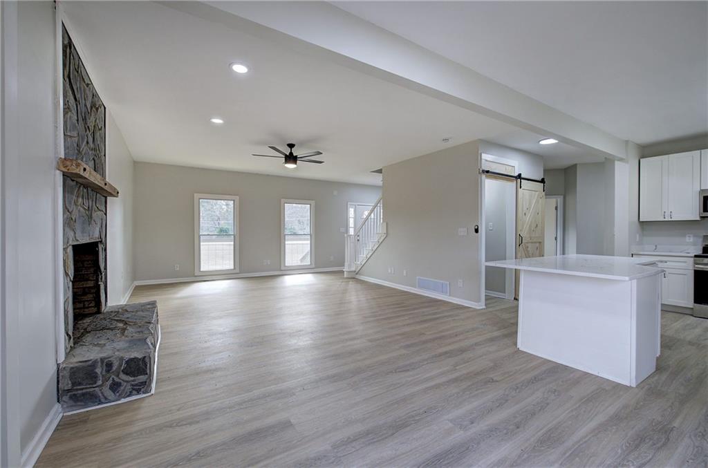 2193 West Ellis Road Griffin, GA 30223 - Photo 6 of 26 a view of an empty room with wooden floor and a kitchen