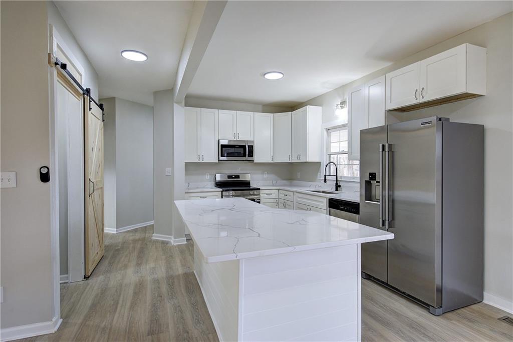 2193 West Ellis Road Griffin, GA 30223 - Photo 7 of 26 a kitchen with stainless steel appliances a refrigerator sink and stove