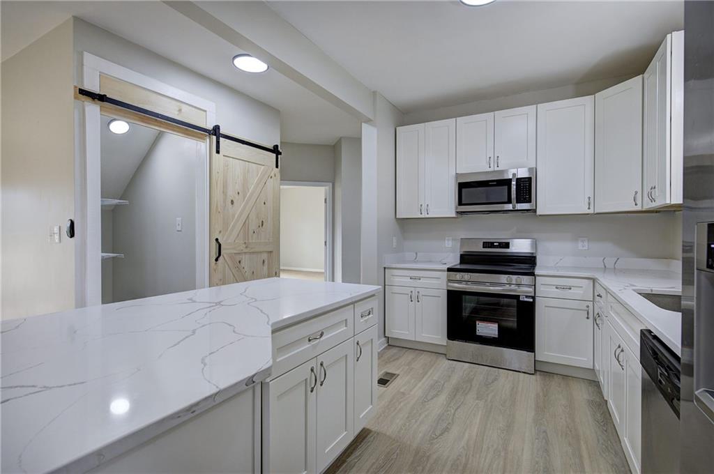 2193 West Ellis Road Griffin, GA 30223 - Photo 8 of 26 a kitchen with stainless steel appliances a stove sink and refrigerator