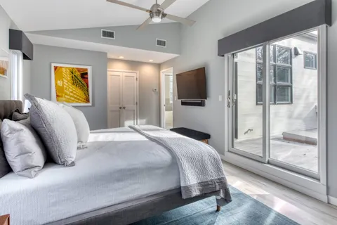 a bedroom with a bed and a flat screen tv