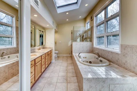 a bathroom with a tub sink and mirror