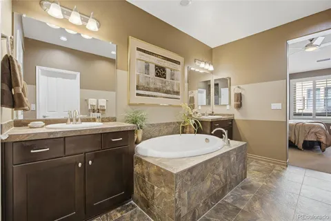 a spacious bathroom with a tub sink and mirror