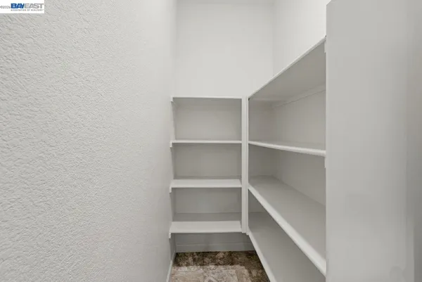a view of empty room with a kitchen
