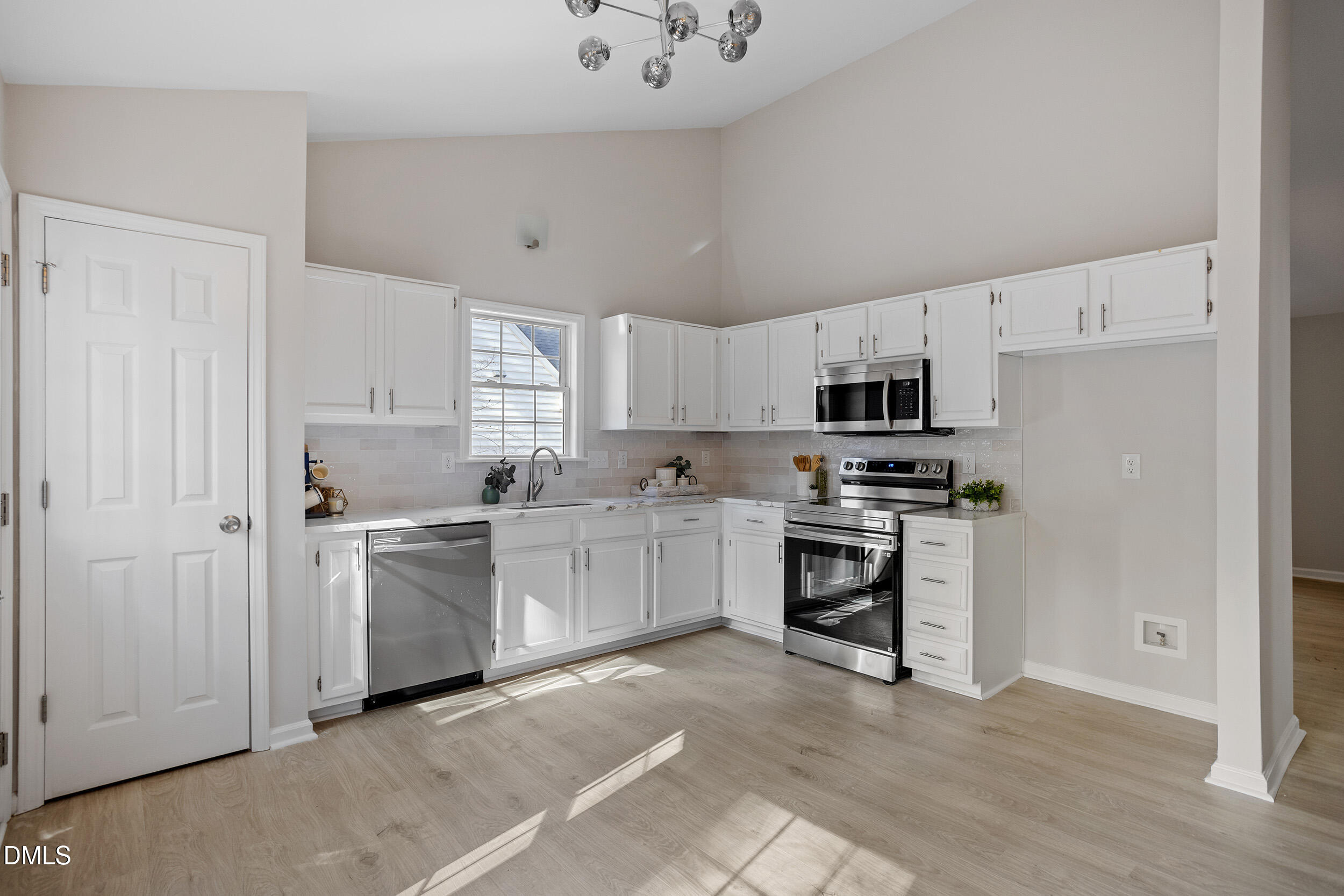 247 Tillamook Drive Wake Forest, NC 27587 - Photo 2 of 30 a kitchen with white cabinets and stainless steel appliances