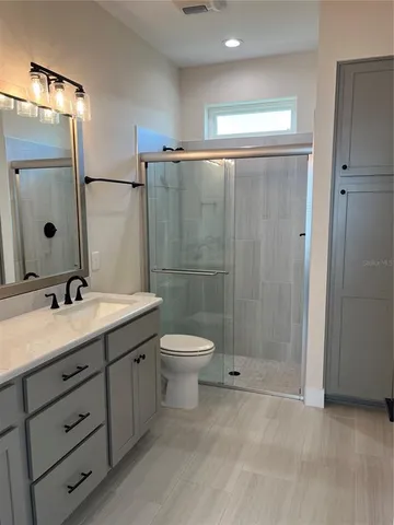 a bathroom with a double vanity sink toilet mirror and shower