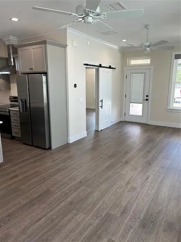 a view of a kitchen with a refrigerator and wooden floor