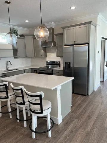 a kitchen with kitchen island a counter space a sink appliances and cabinets