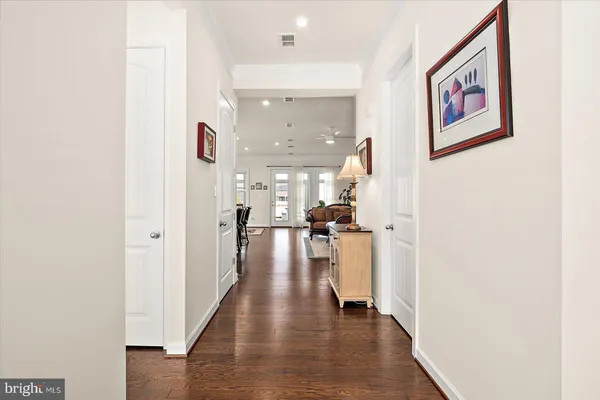 a kitchen with stainless steel appliances granite countertop a dining table chairs stove refrigerator and cabinets