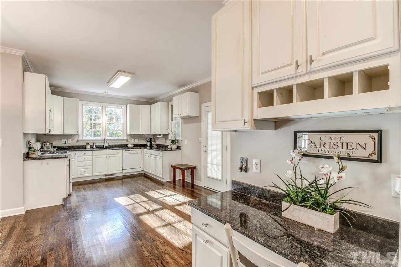 9024 Hemingwood Court Raleigh, NC 27613 - Photo 16 of 28 a kitchen with granite countertop white cabinets a counter space and stainless steel appliances