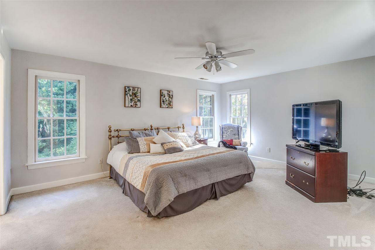 9024 Hemingwood Court Raleigh, NC 27613 - Photo 18 of 28 a spacious bedroom with a bed a couch and a dresser next to a window